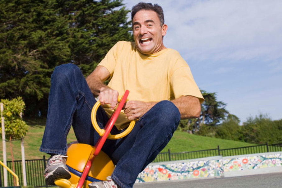 middle aged man playing at playground