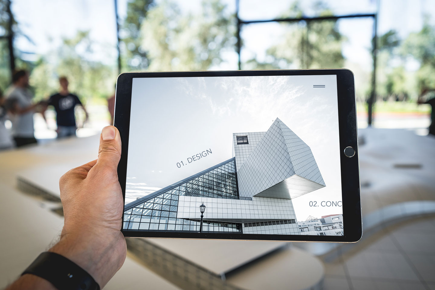 Man holding a tablet with a website for an architecture firm up