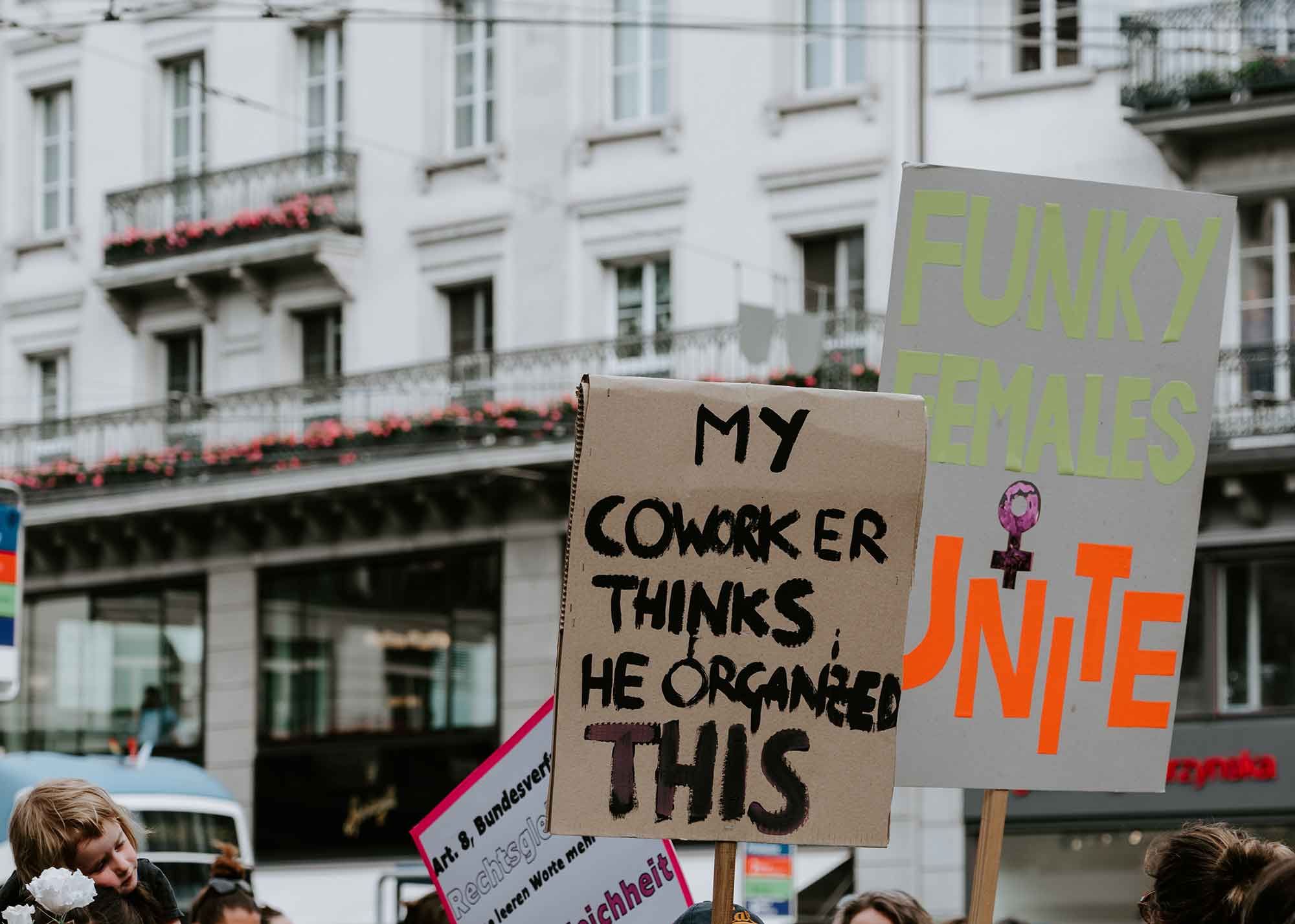 A protester holding a sign that says "My coworker thinks he organized this"