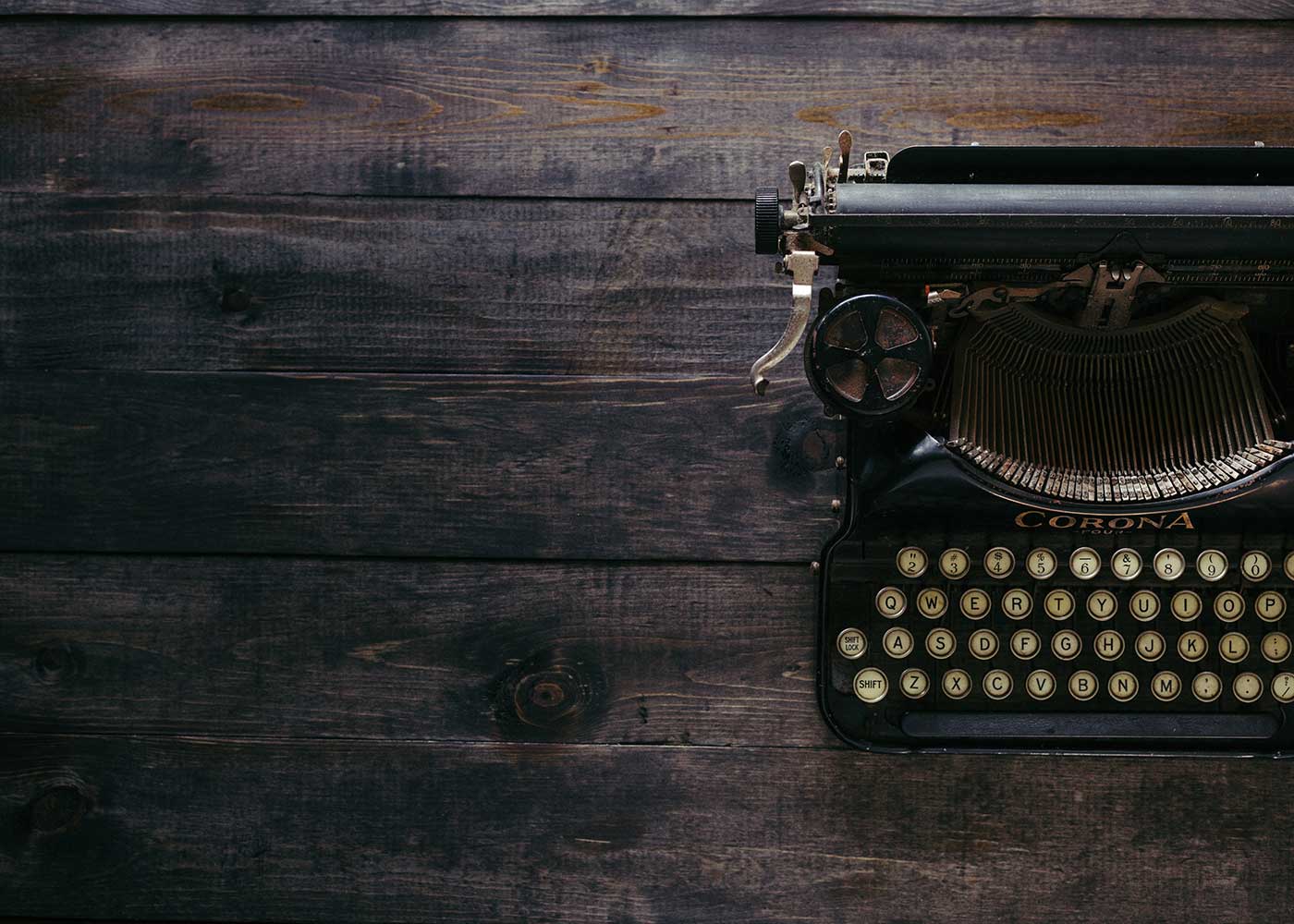 Old black typewriter on a wooden desk