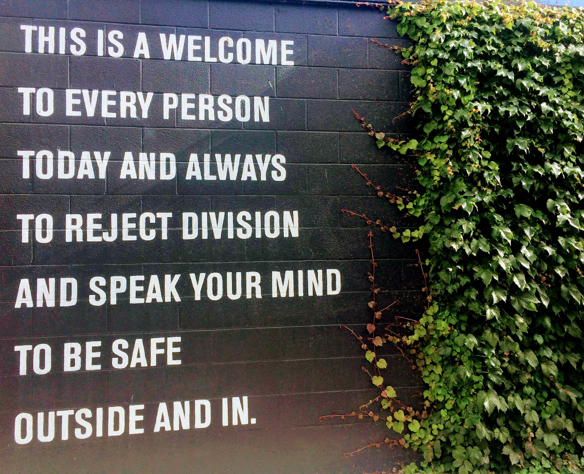 one wall blakc with white letters encouring people to be themselves