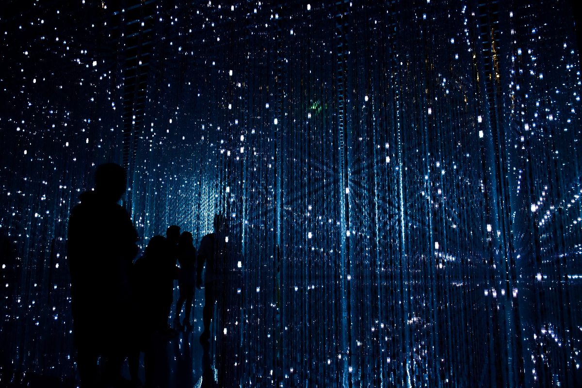 dark silhouettes of peopl ein a maze of blue techno lights.