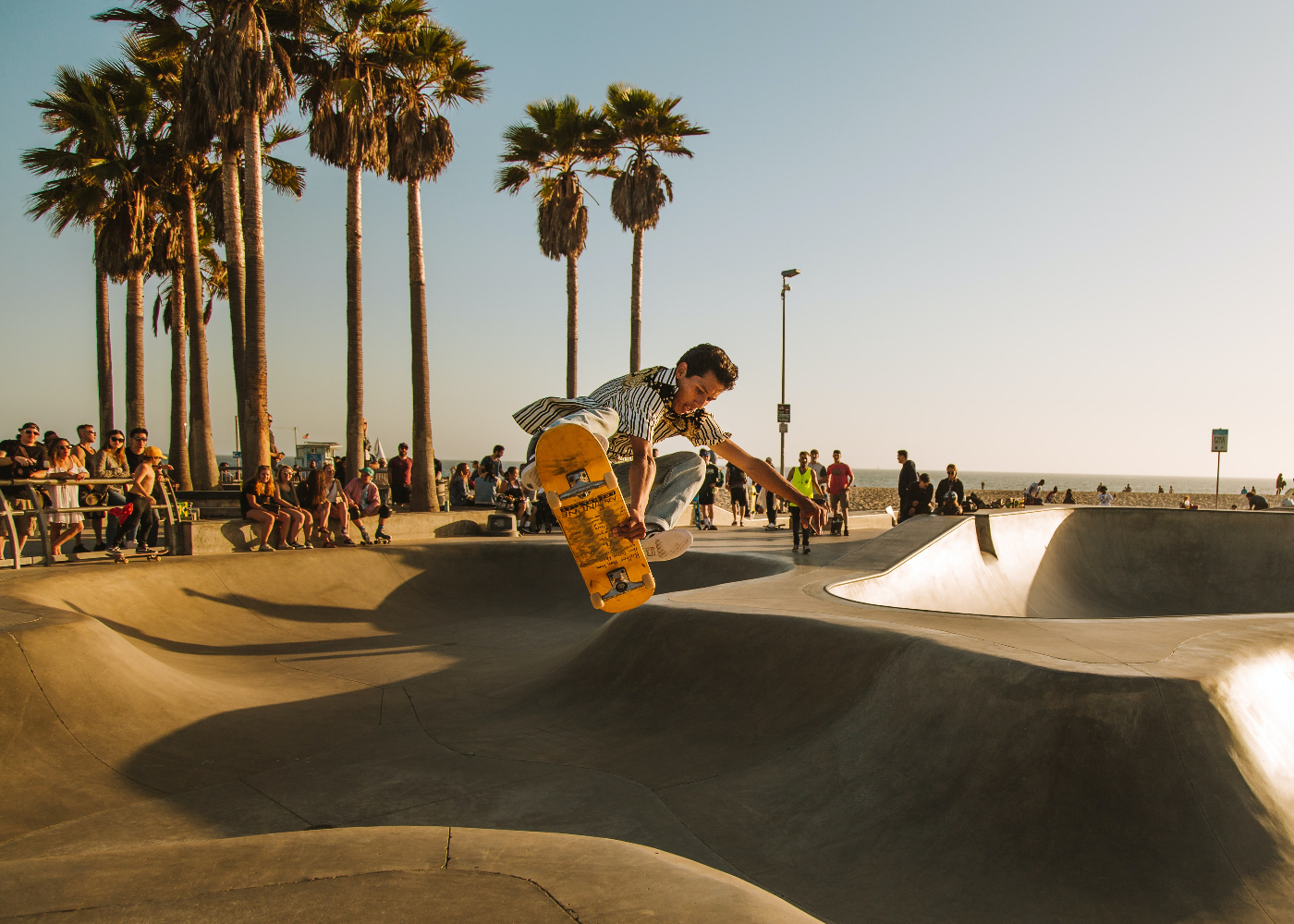 A boy in mid air on a skateboard in a seaside skate park