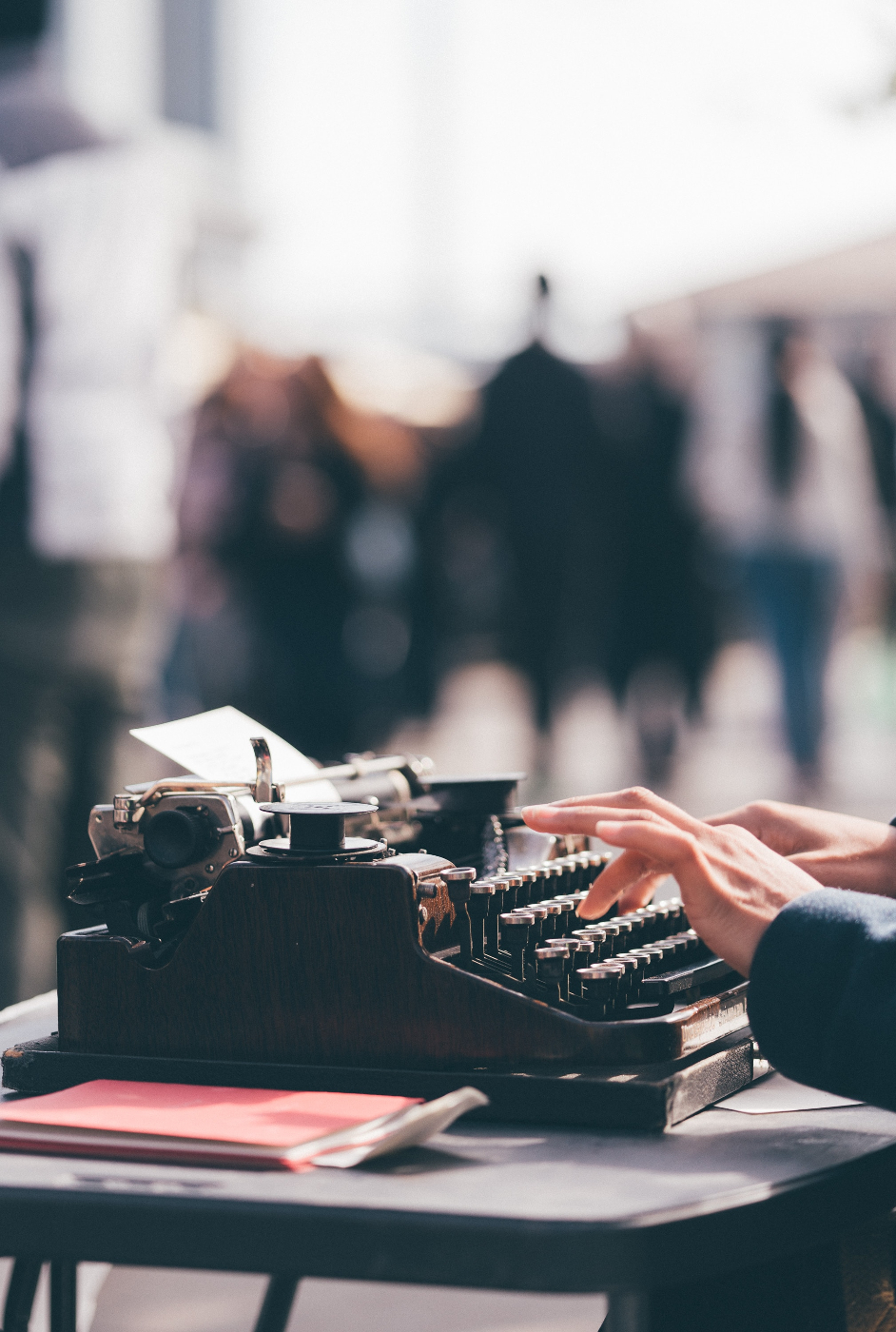 A woman's hands working an old fashioned typewriter