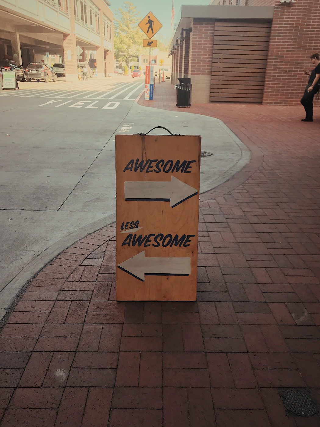 A street sign reading awesome with an arrow pointing right and less awesome with an arrow pointing left