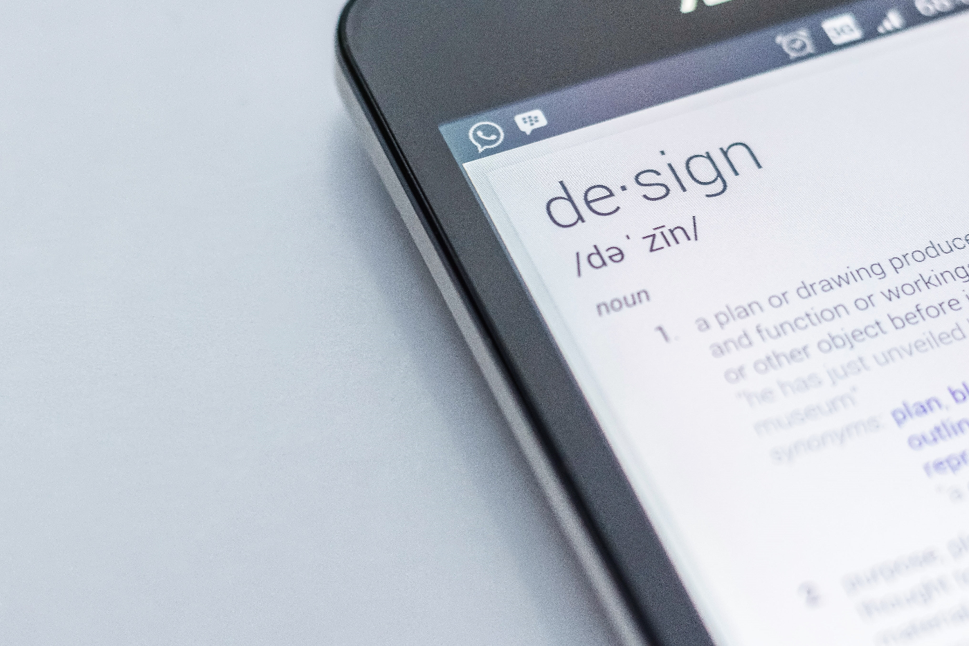 Close up of a smartphone screen with the definition of design showing