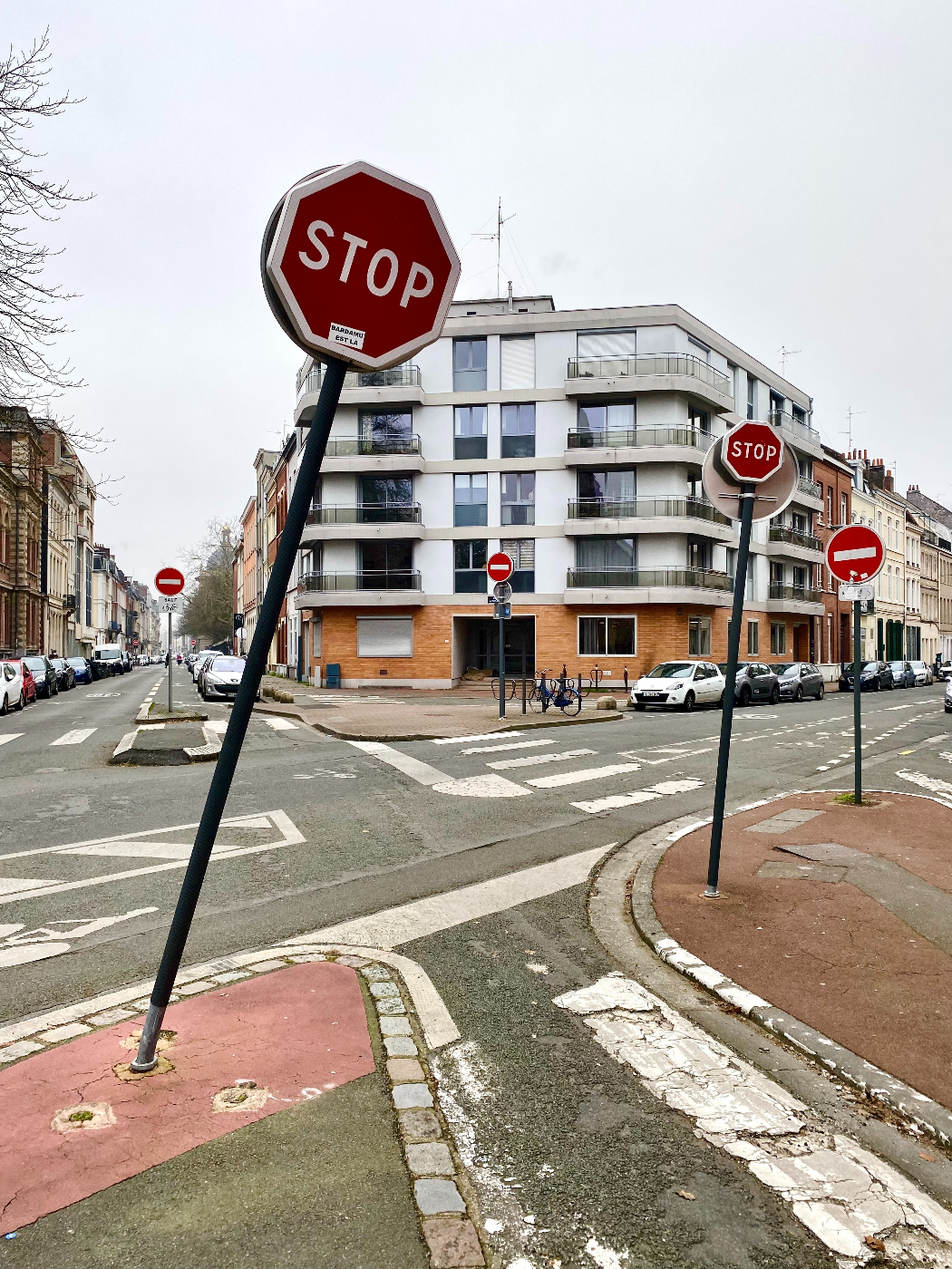 an intersection with five stop signs leaning