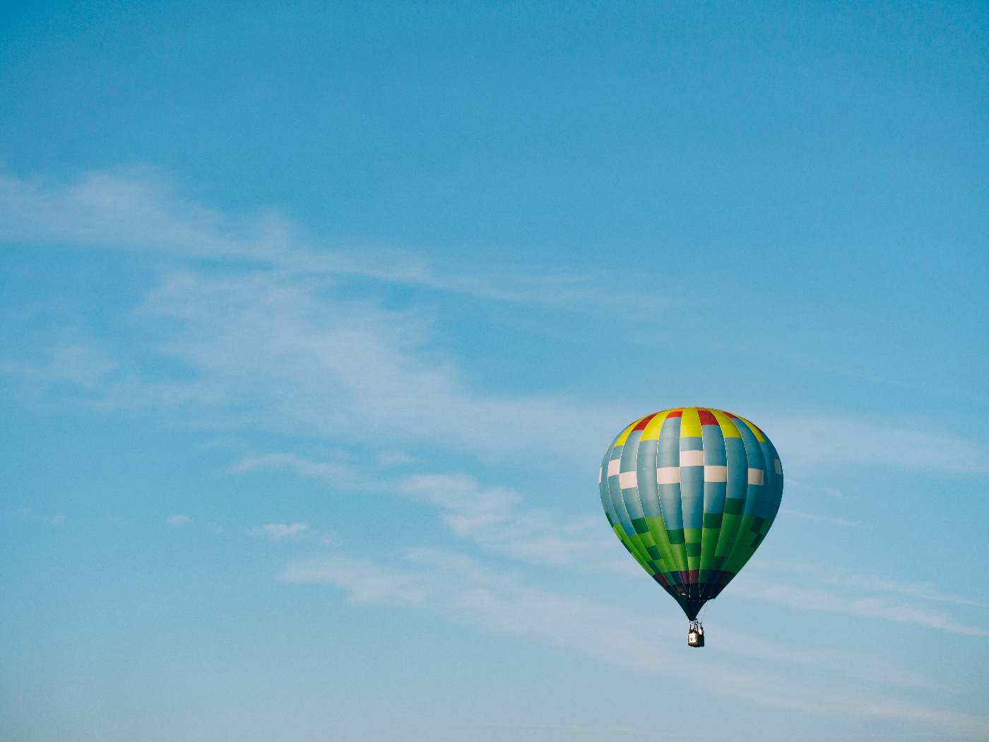 A multicolored hot air baloon floating