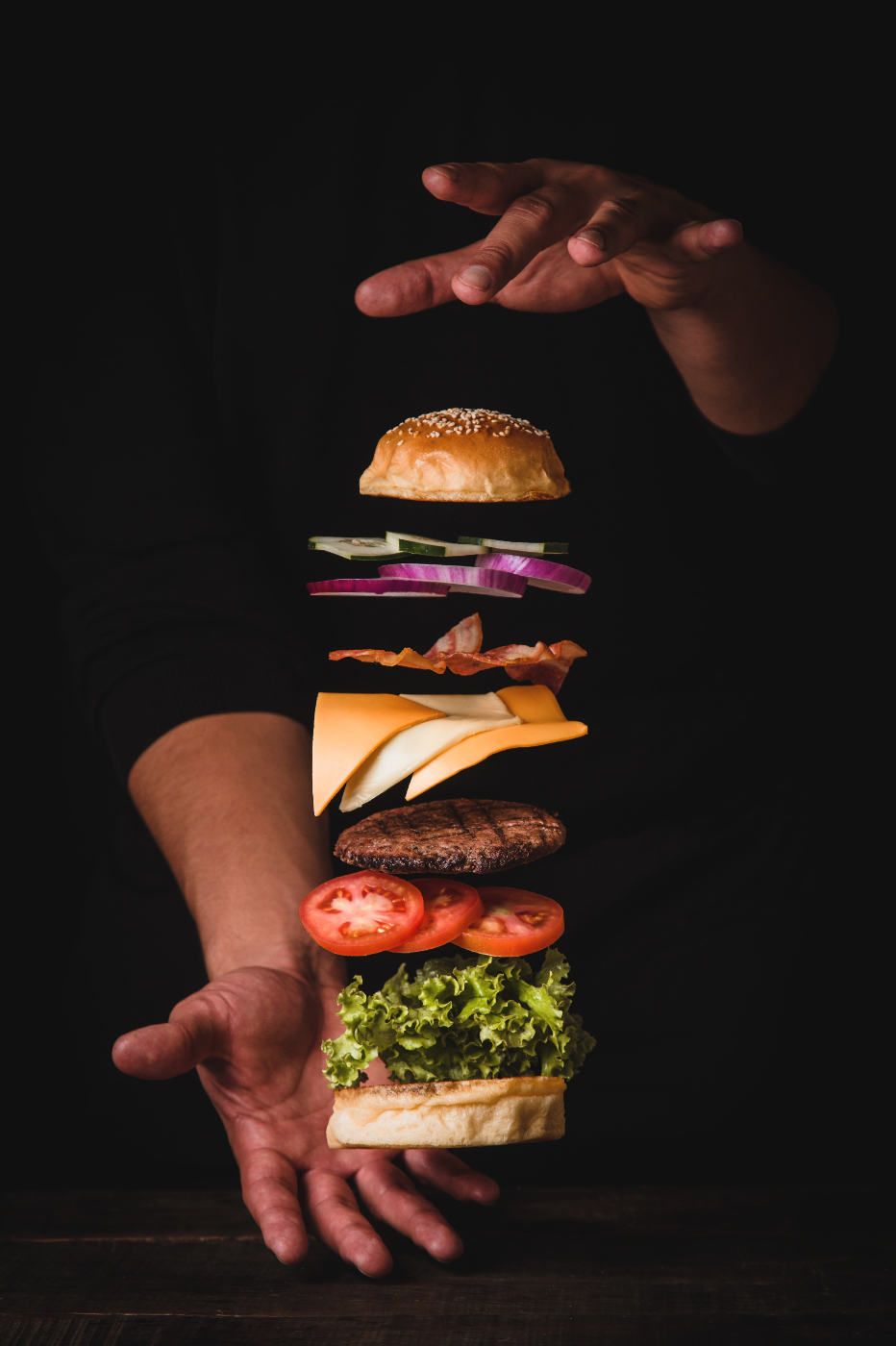 a stop motion image of a burger with all the fixings coming together