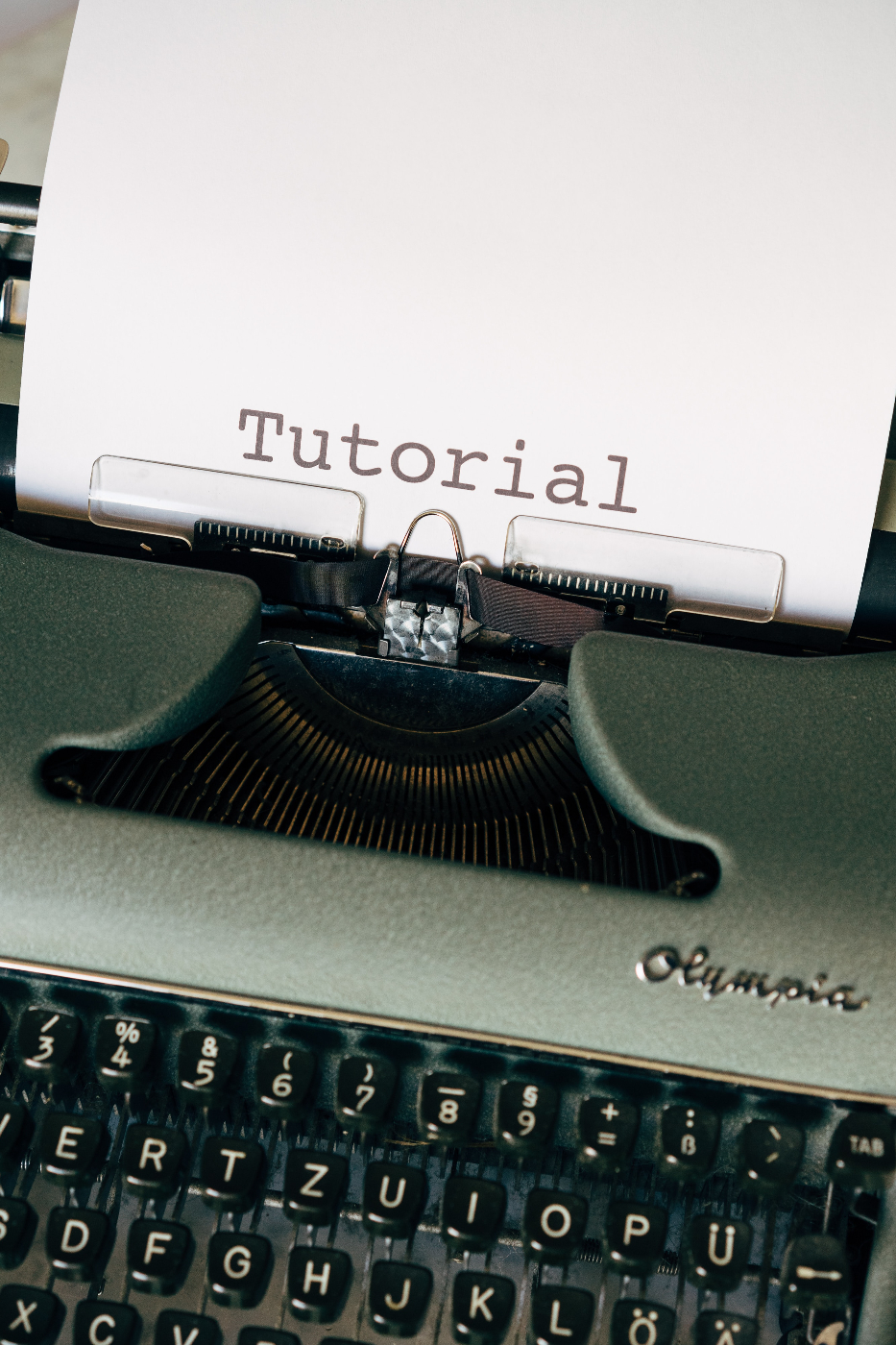 an Olympia typewriter with one sheet in the roller reading Tutorial