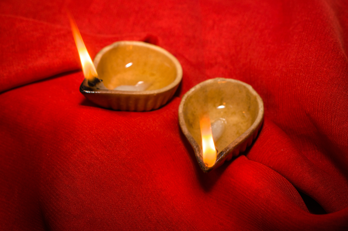 two candle bowls on red cloth