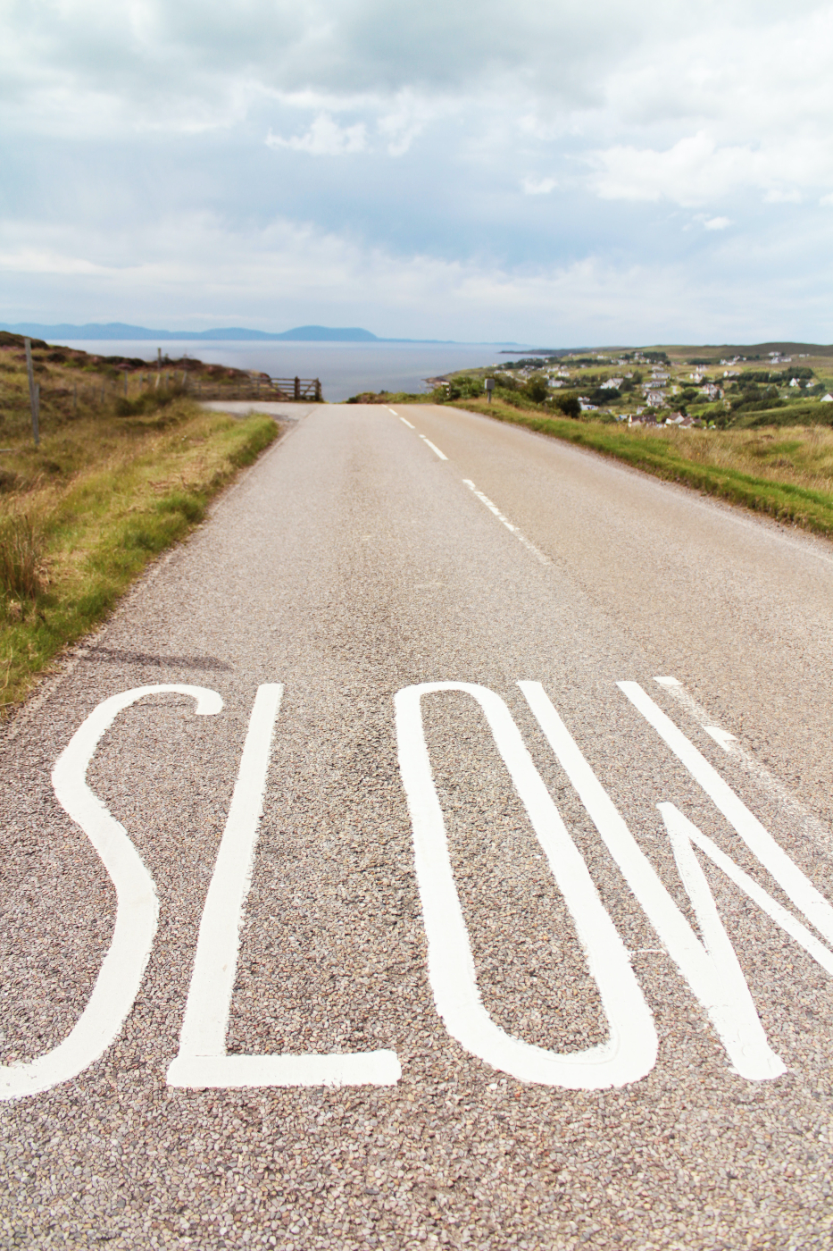 a seaside street with the word slow painted on the road