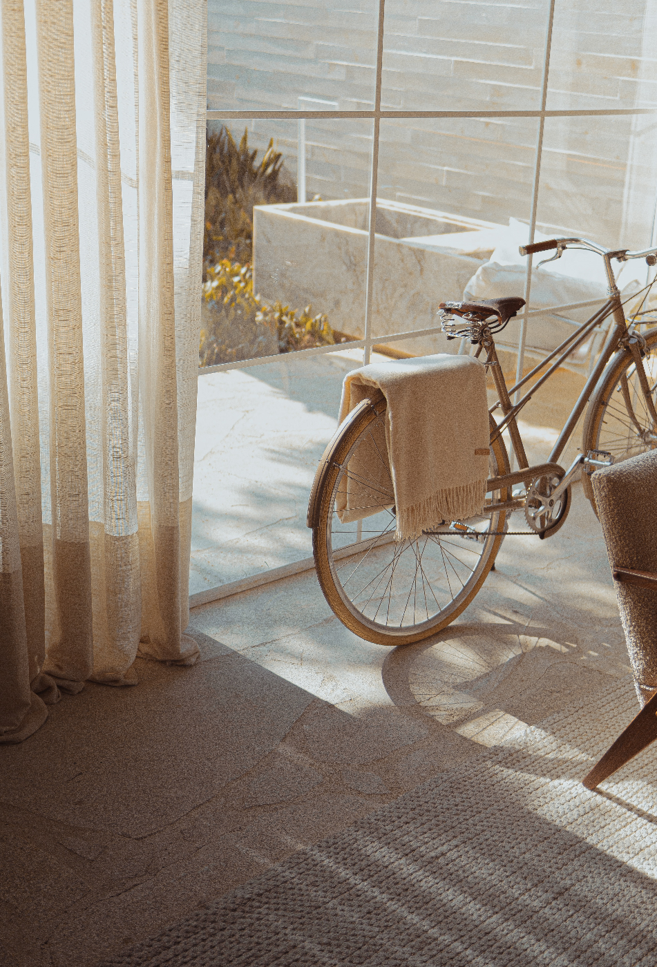 A beige bike in a beige room near a glass door