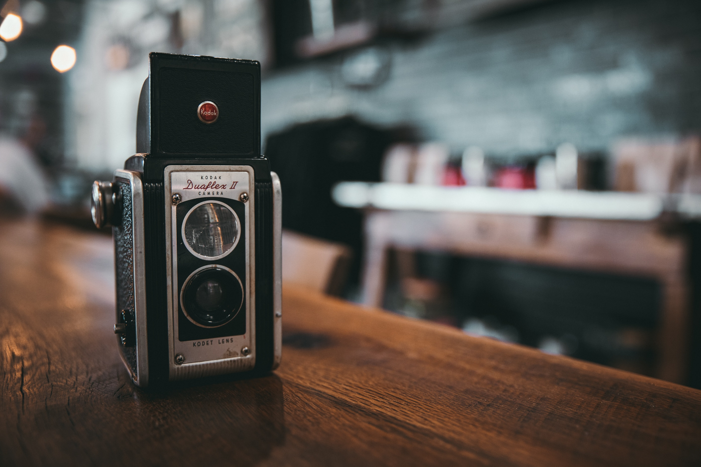 A Kodack Duaflex II camera sitting on a wood table