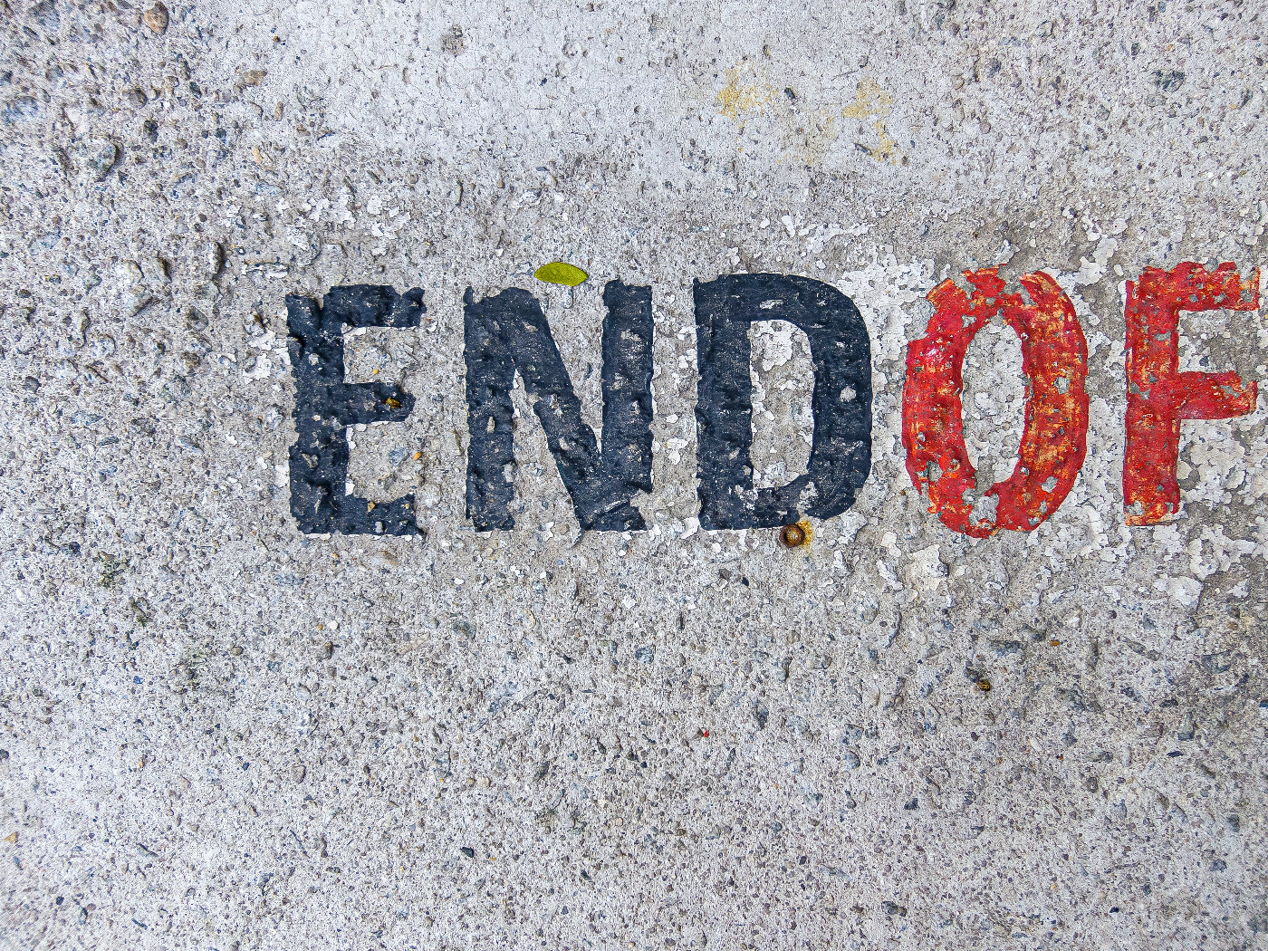 The words End inblue, Of in red, painted on concrete