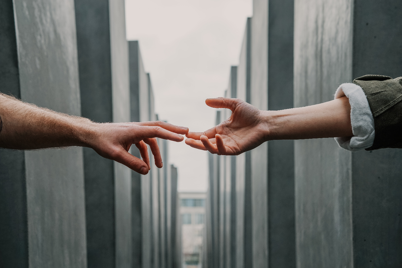 Two hands reaching toward each other, finger tips touching