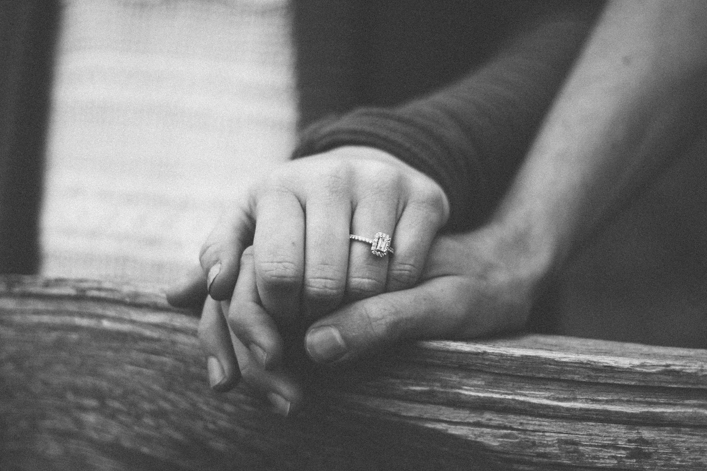 A grey scale image of a couple holding hands