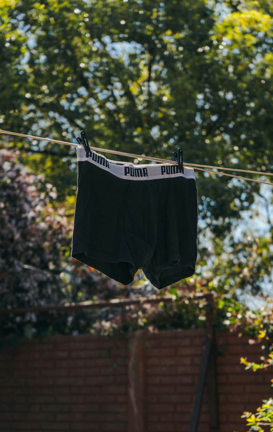 a pair of men's Puma black boxer-briefs hanging on a clothes line
