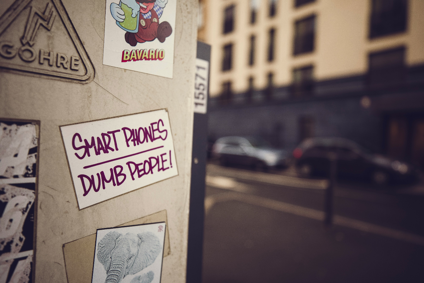 A bill on a wall that reads Smart Phones Dumb People