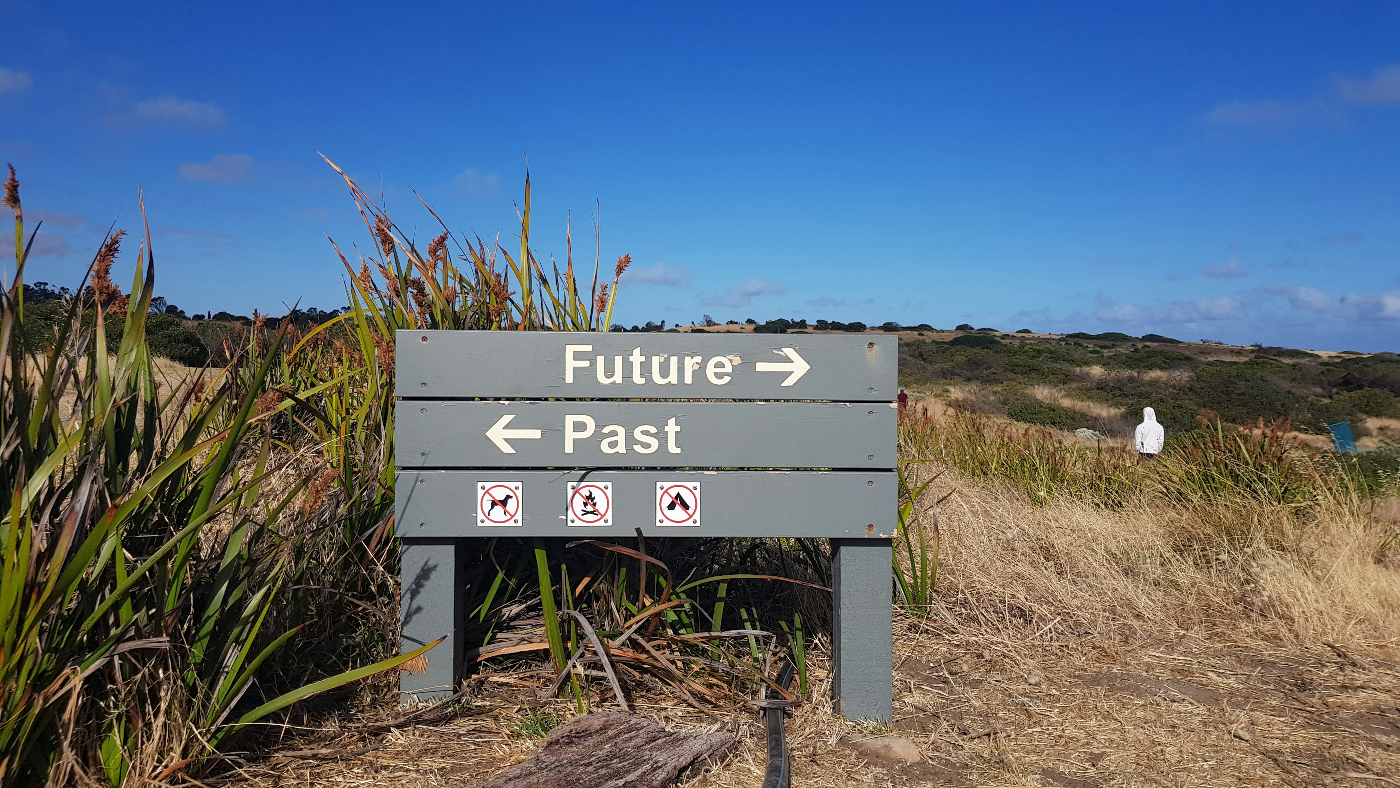 A sign at the beach reading Future and past