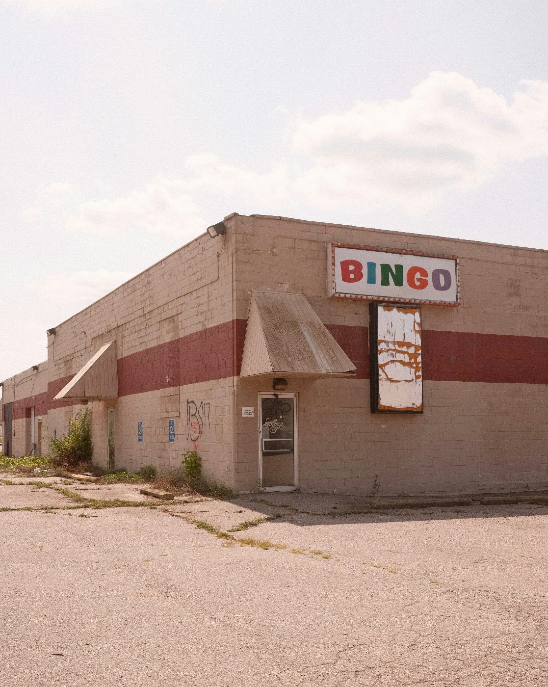 A broken down building with a neon sign on the side announcing BINGO