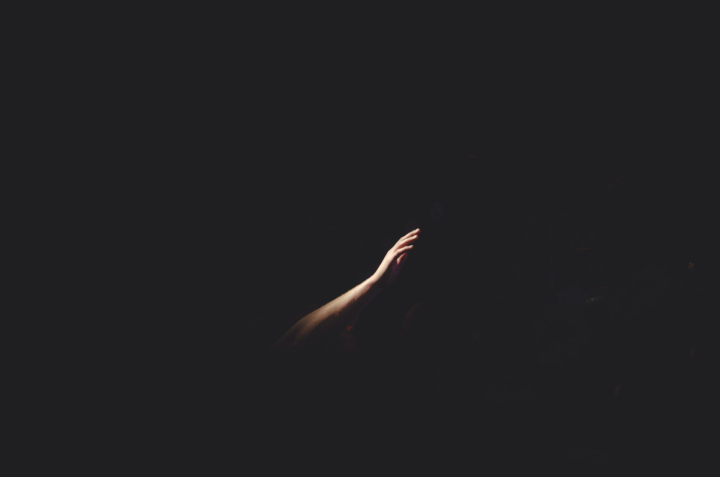 An arm sticking out of total darkness