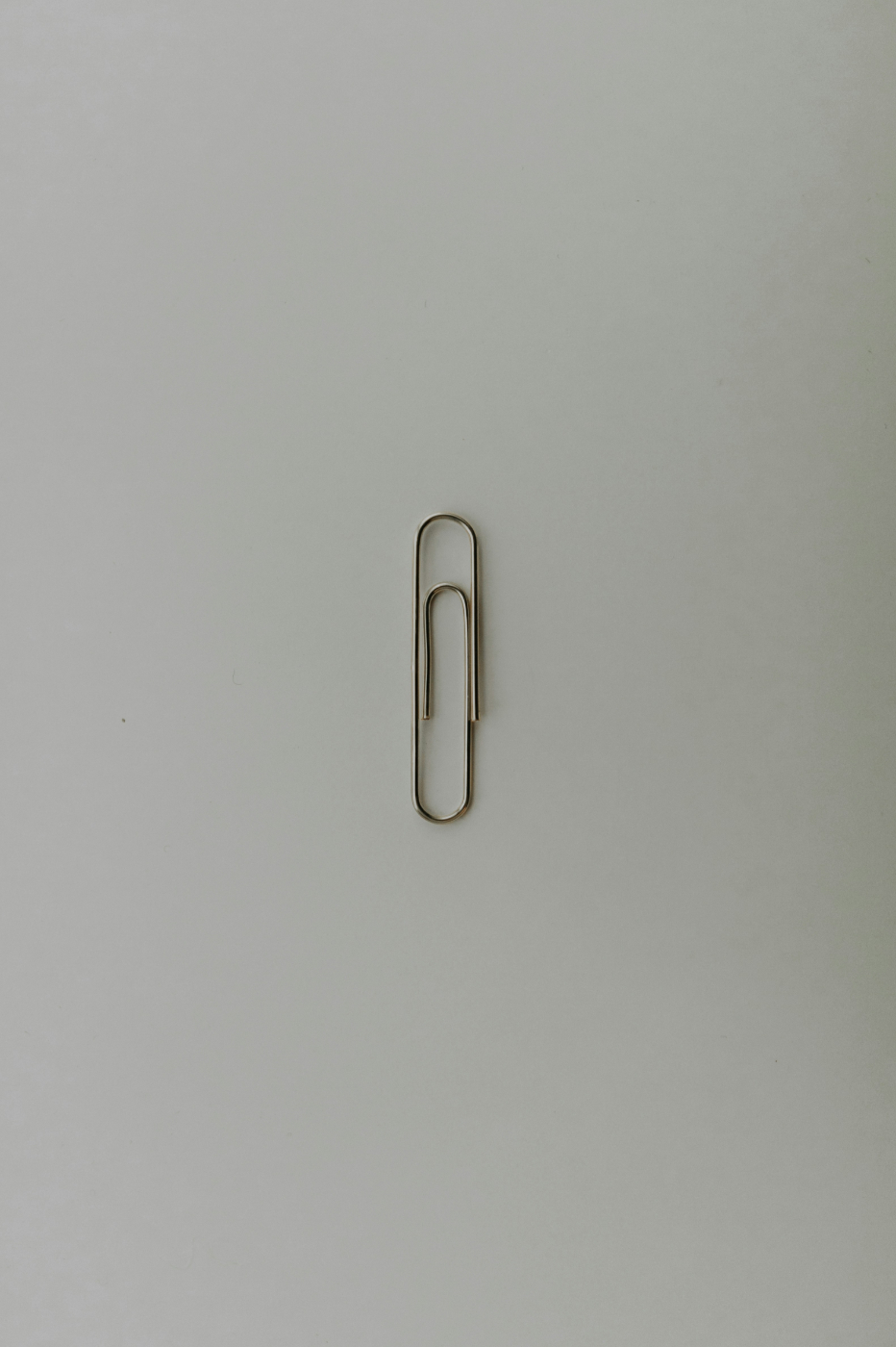 A single paper clip on  a gray background