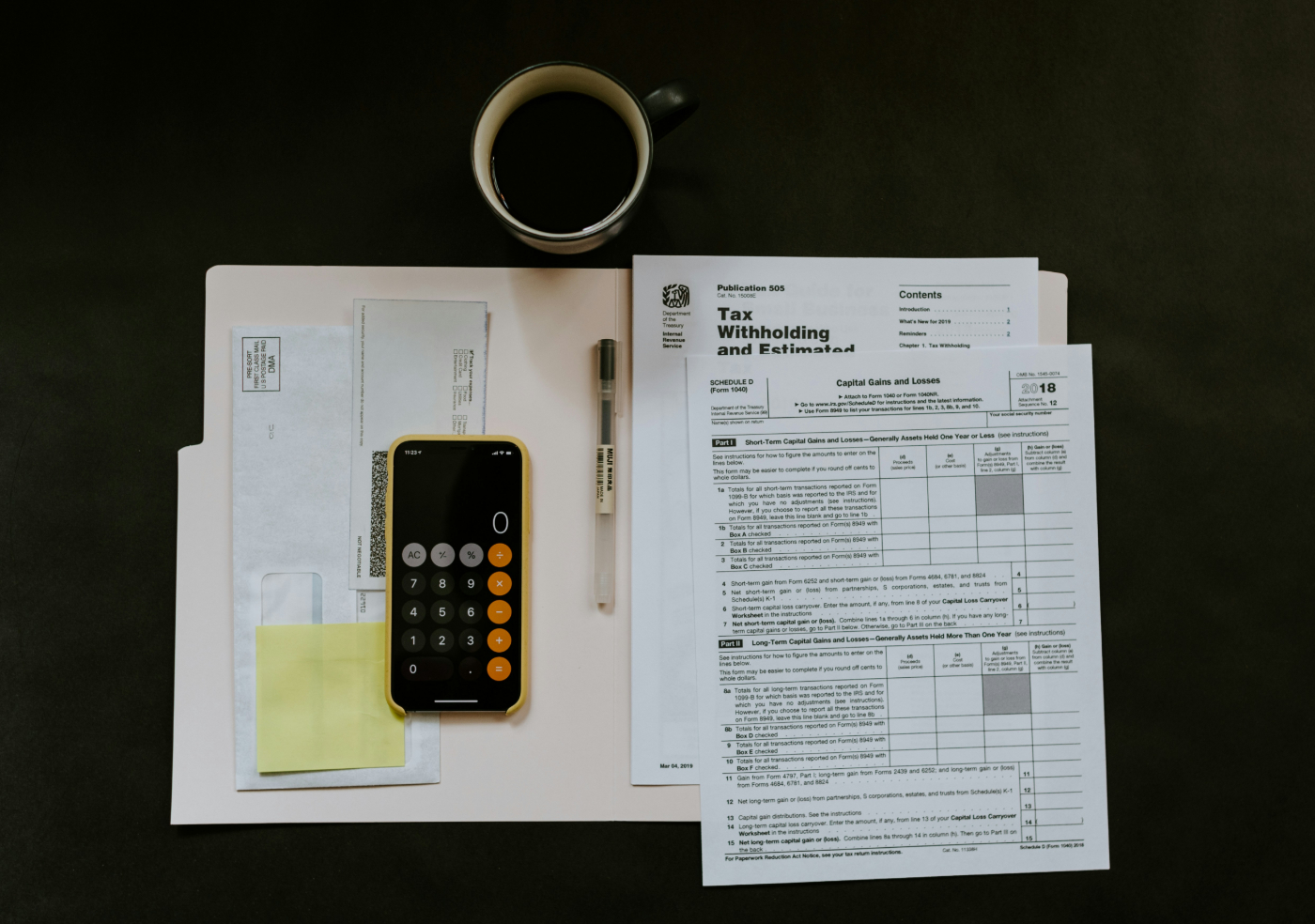 Tax forms, calculator and a cup of black coffee