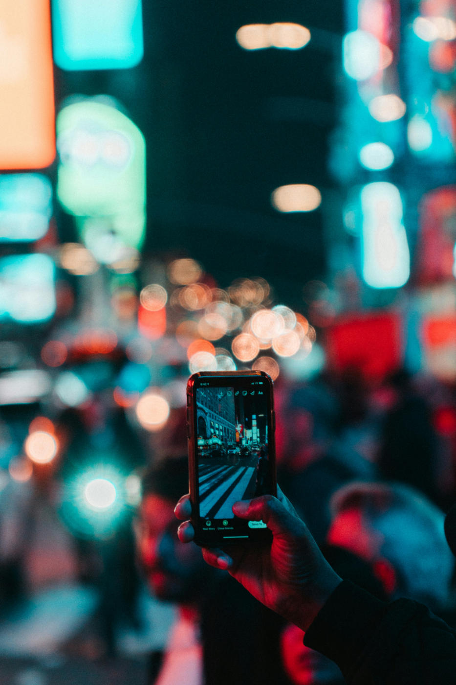 A person taking a photo of a city at night