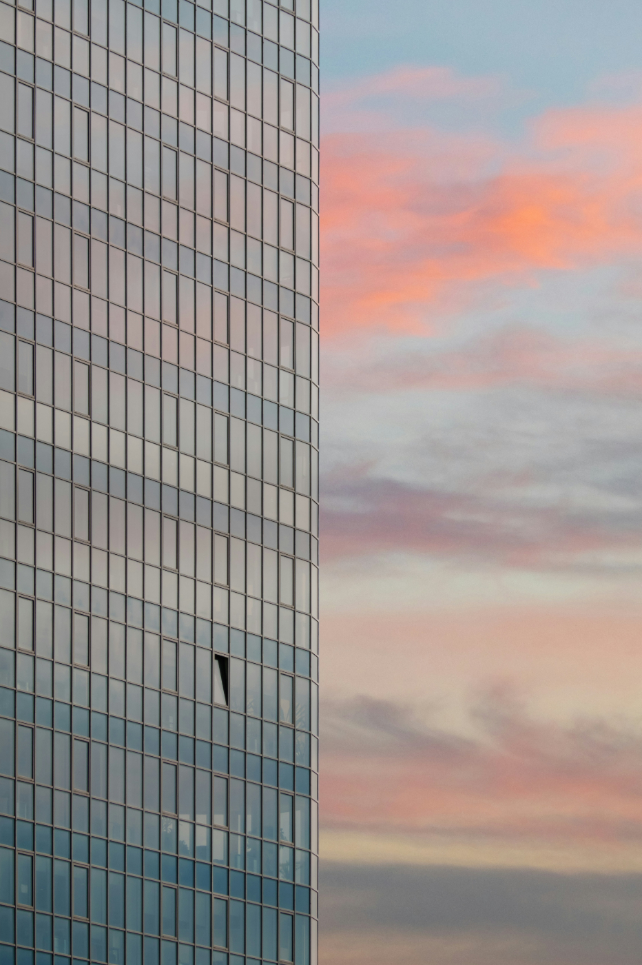 A skyscraper with thousands of windows and one open window