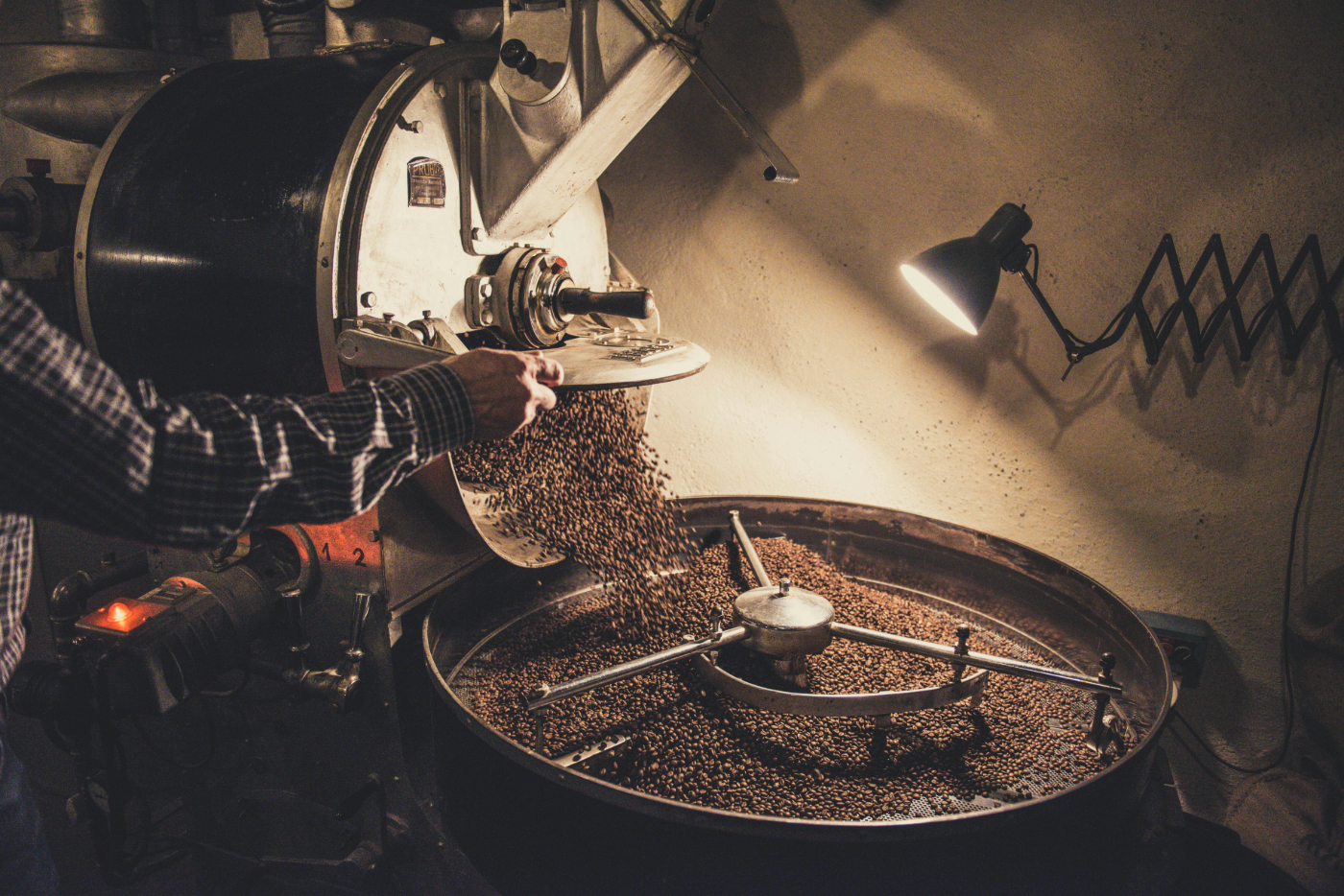A person emptying a coffee roaster