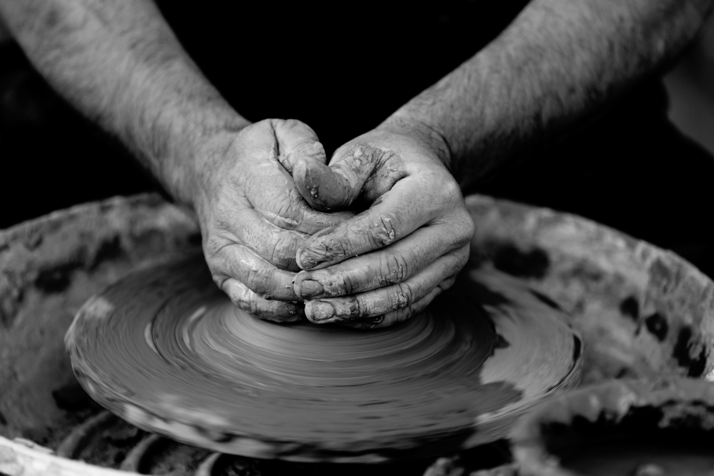 A man's hands working on a potter's wheel