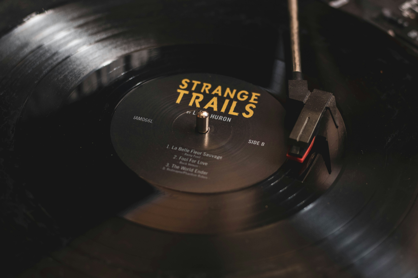 A record album on a turn table, the label reads Strange Trails