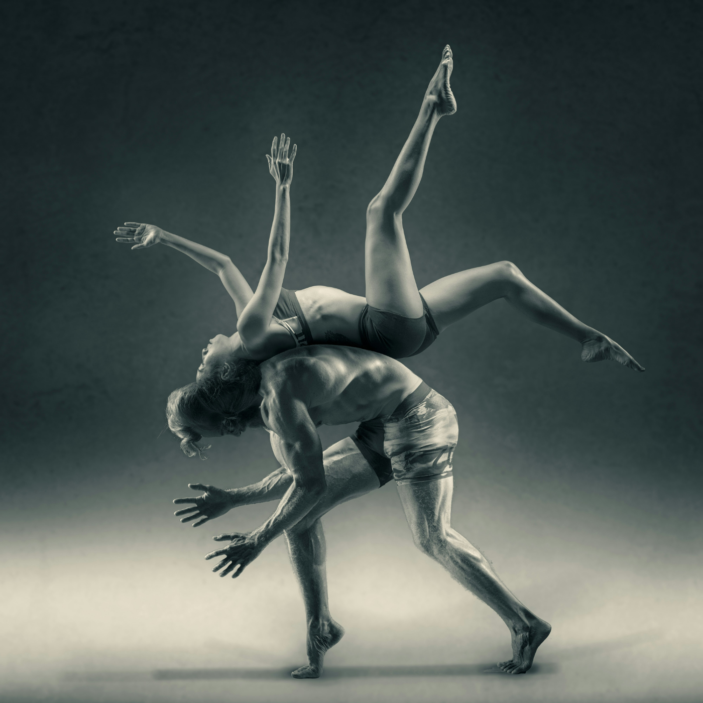 A male and female dancer, the male has the female on his back, her back to his