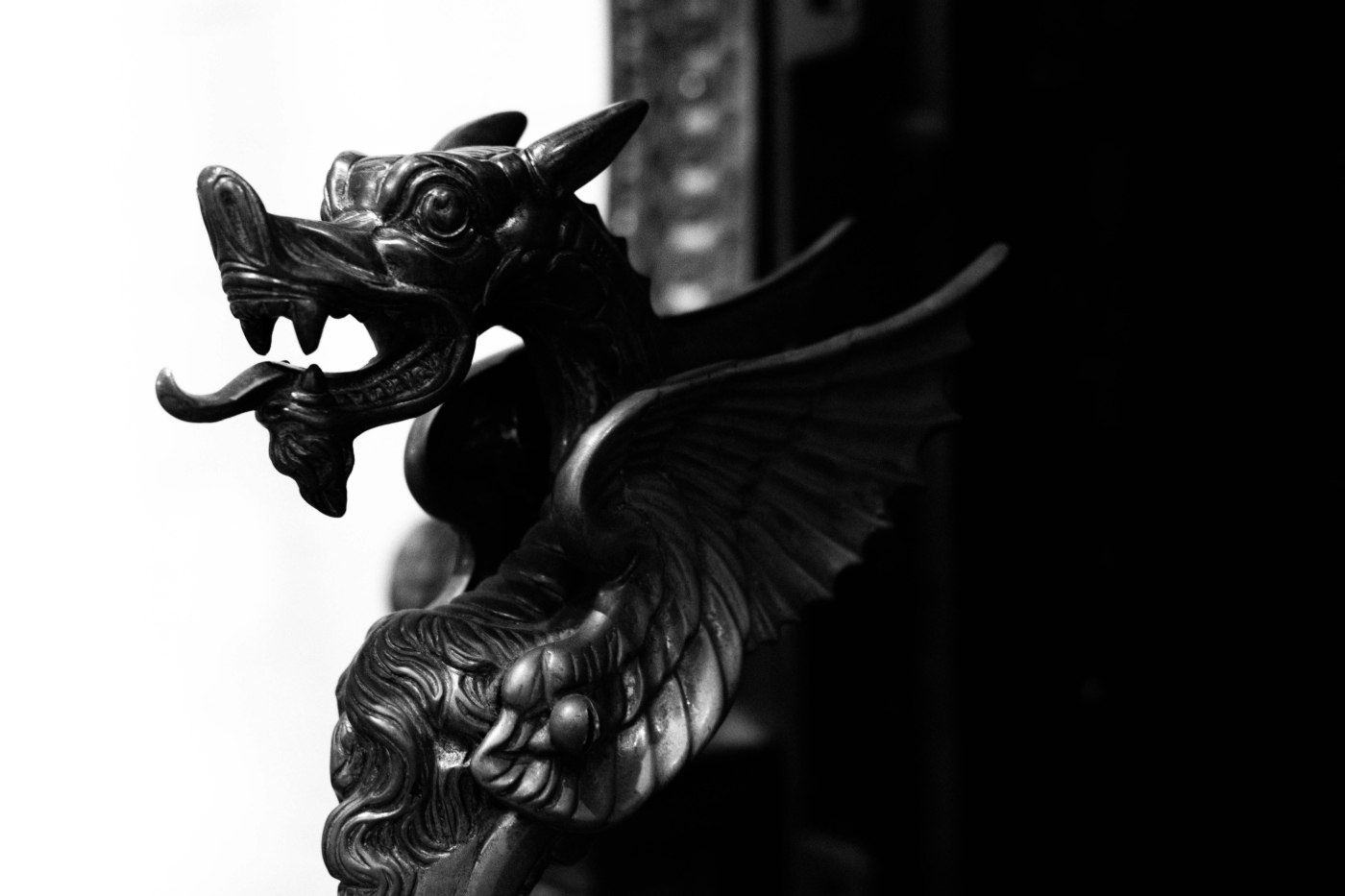 A gray scale photo of a dragon statue