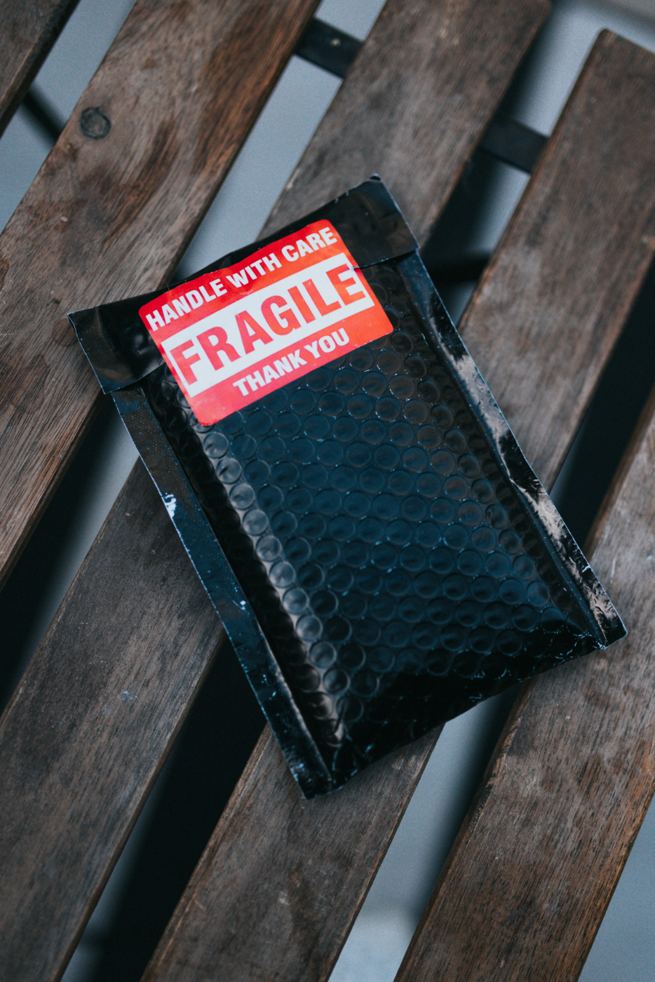 A black package with a red fragile sticker on it