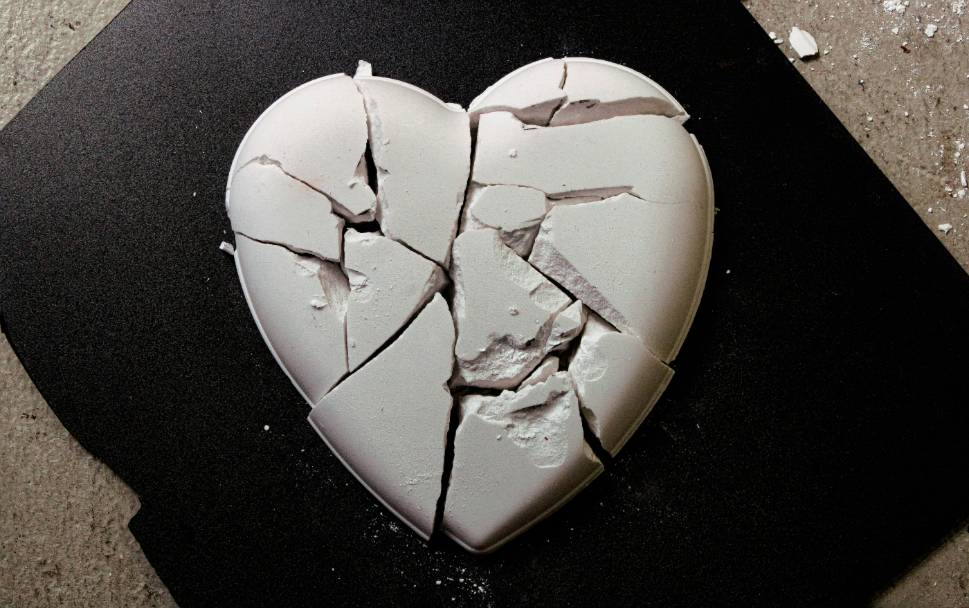 A shattered white heart shaped stone on a black mat
