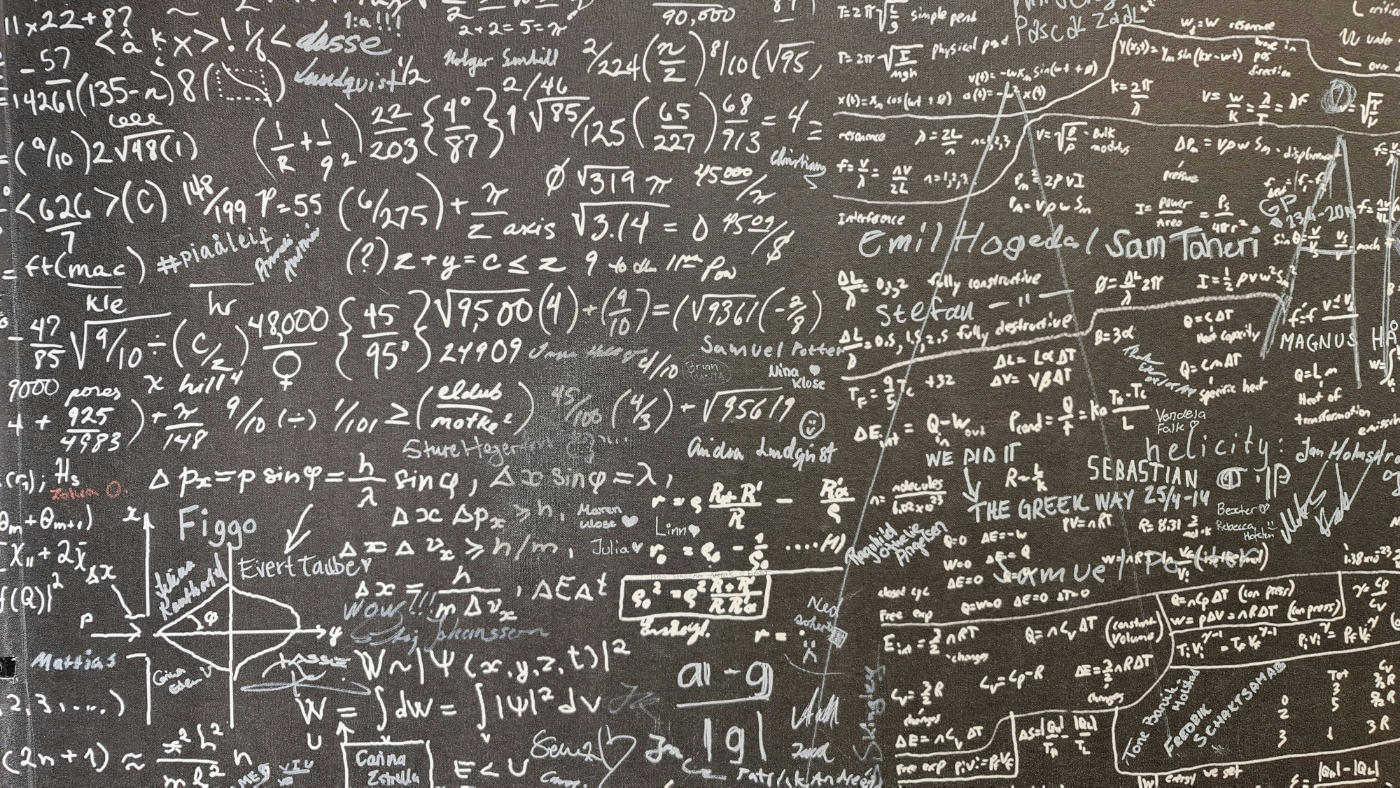 A chalkboard covered with a complex math equation