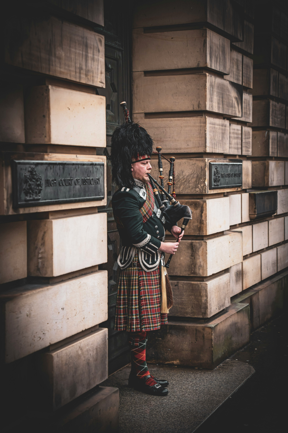 A bagpiper in full traditional dress