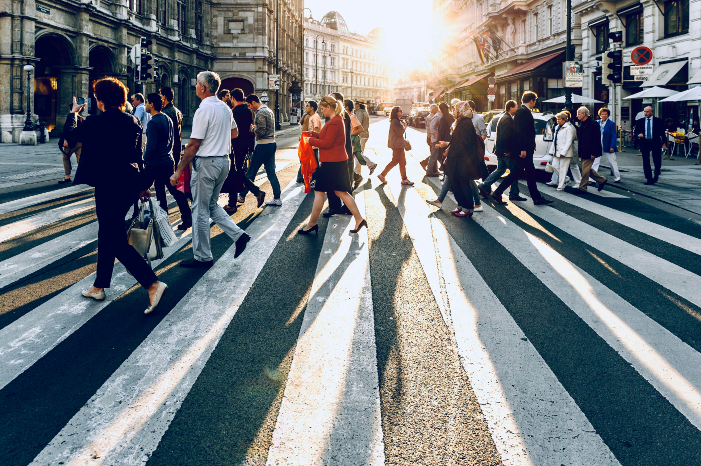 Many people in a city using a crosswalk