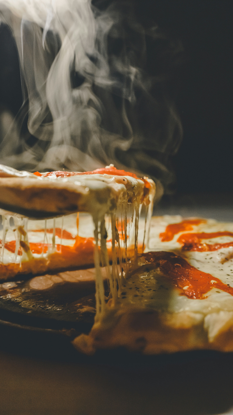 A slice being pulled off a pepperoni pizza and steam filling the screen