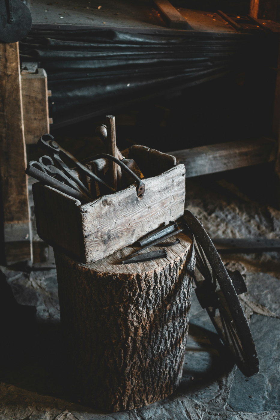 An old, old tool box with tools sitting on a log