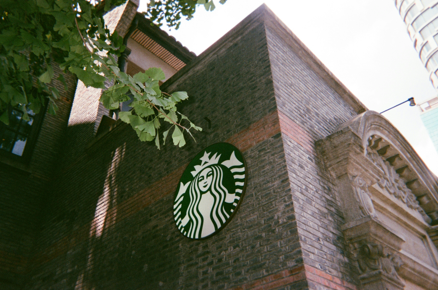 A brick building with a Starbucks Logo n the side