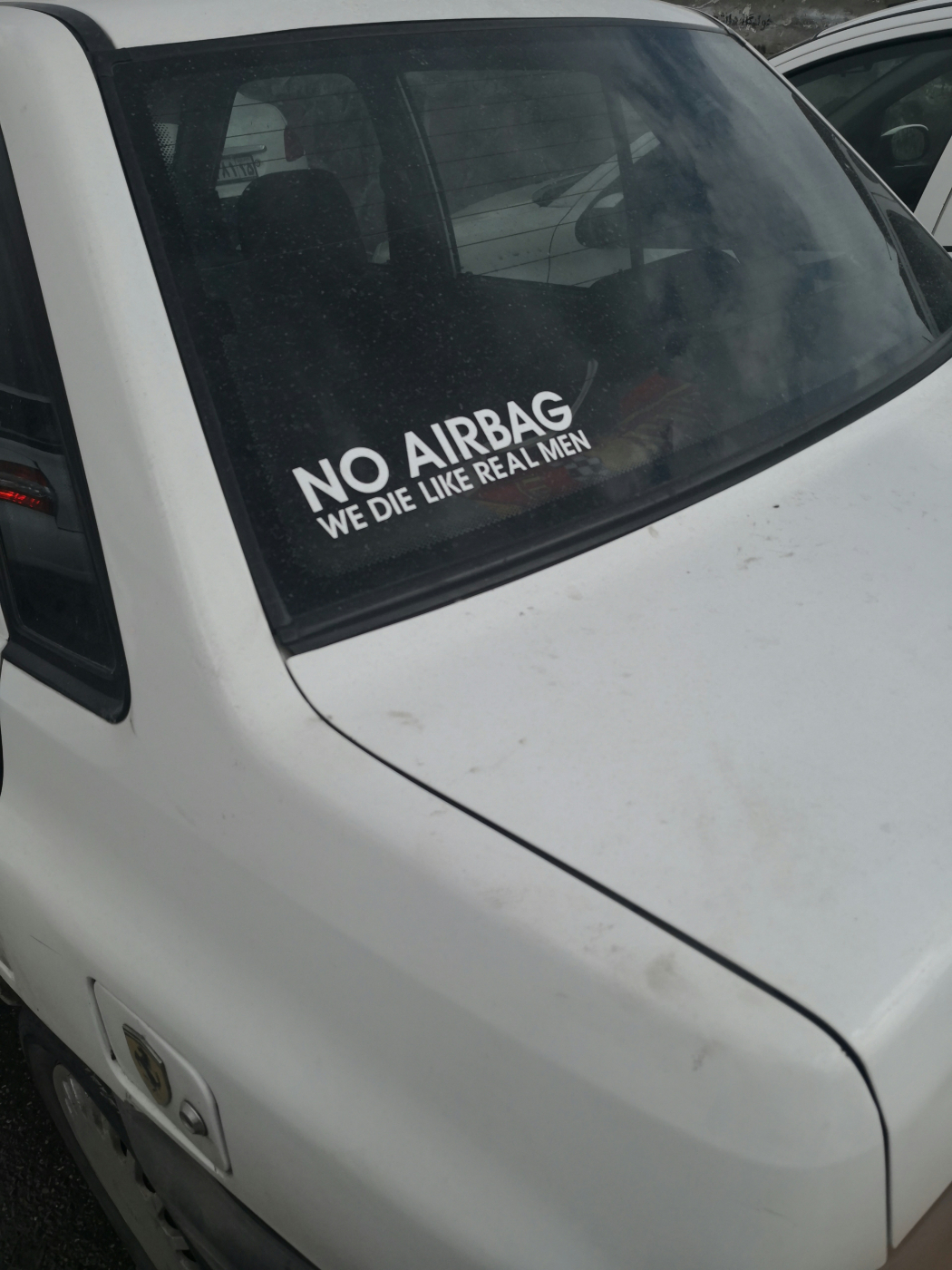 A sticker on a car window reading; No Airbag, We Die Like Real Men
