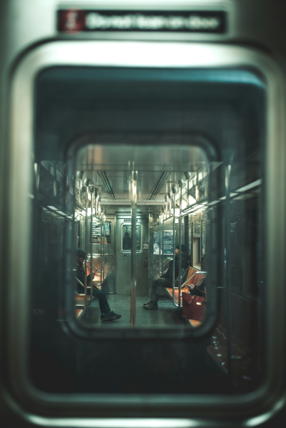 Interior of a subway car with two people riding