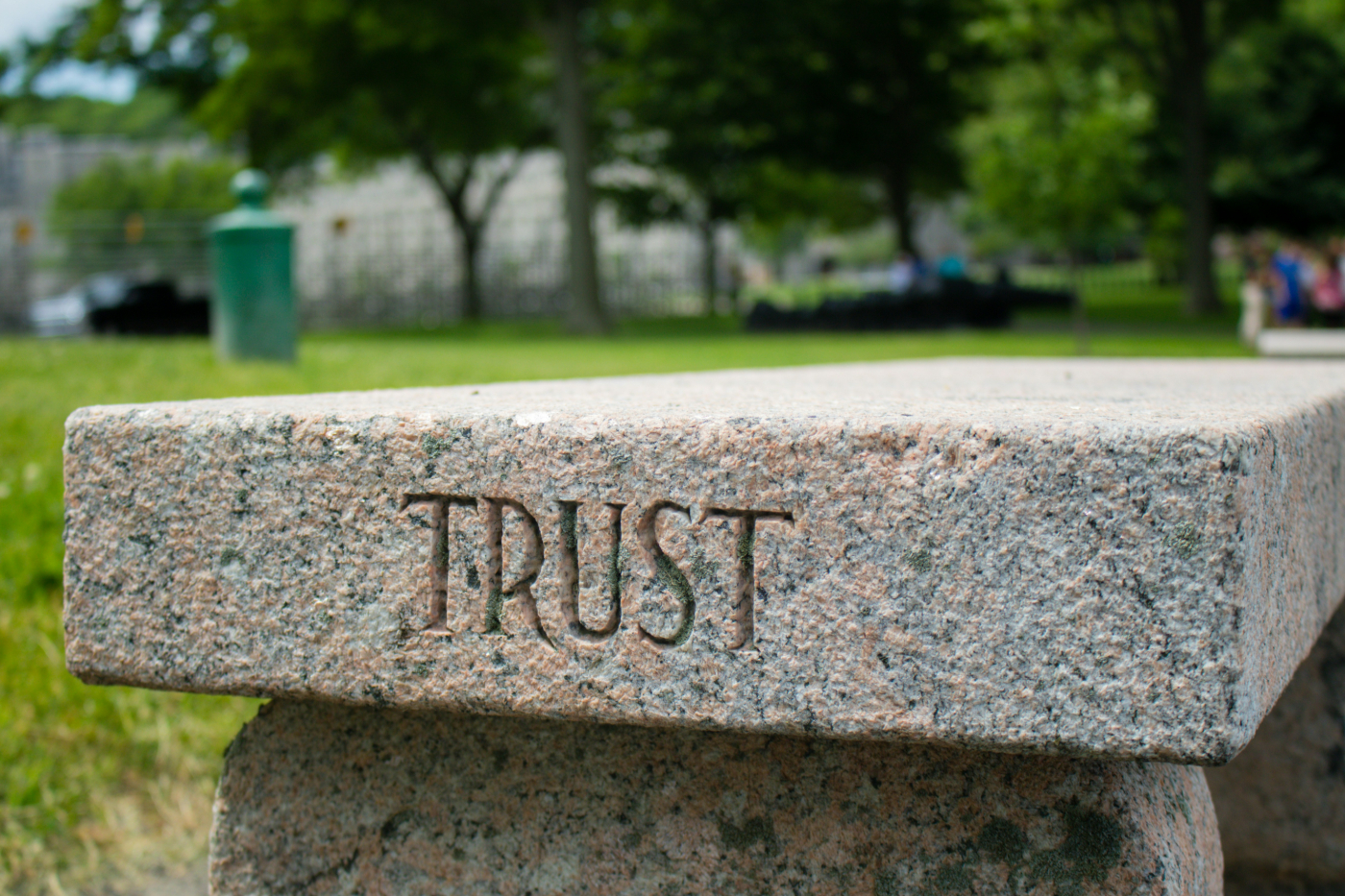 A stone bench with the word Trust engraved on one end