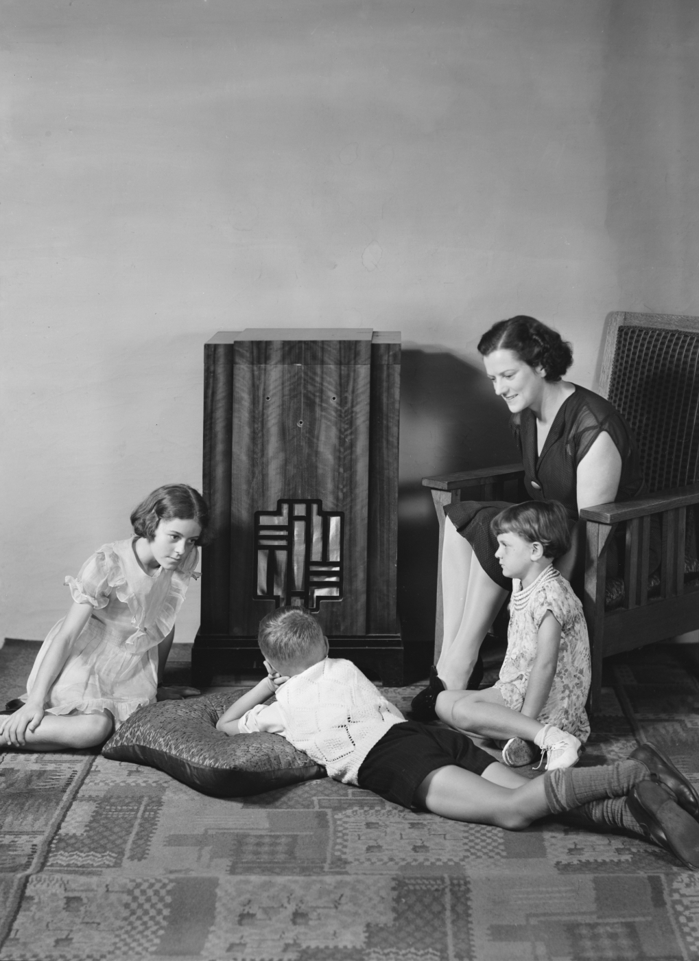 Mom and her three kids gathered around the wireless