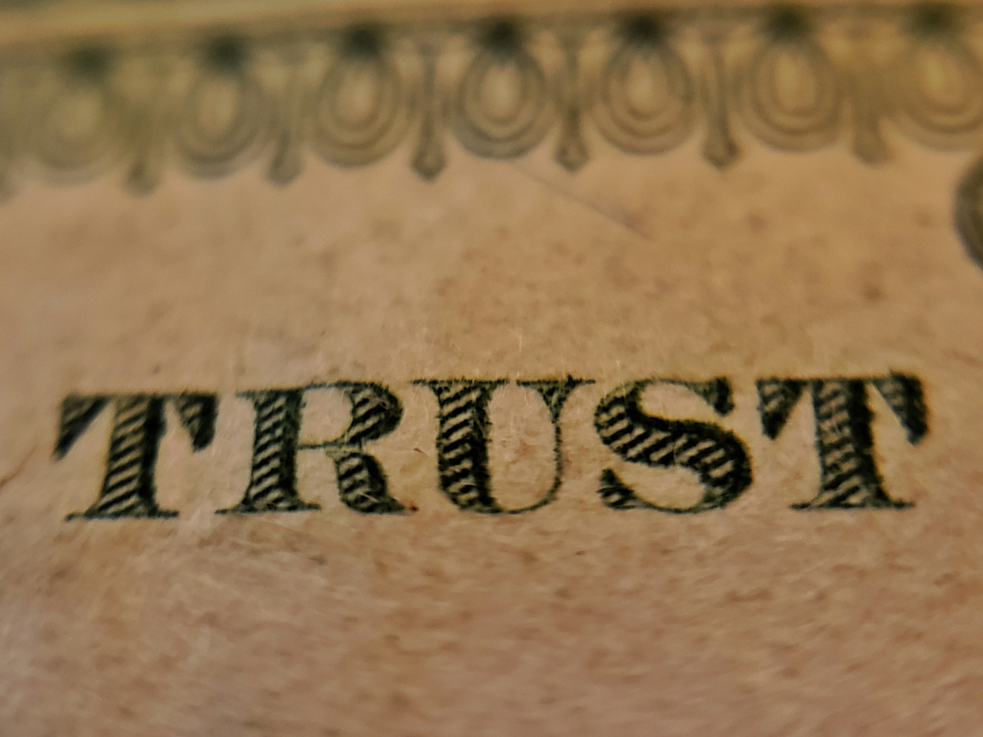 Close up on the word TRUST on a piece of American currency