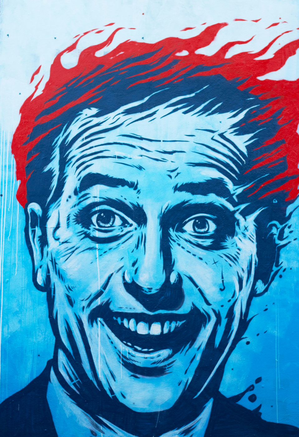 A saturated blue portrait of a man with burning hair