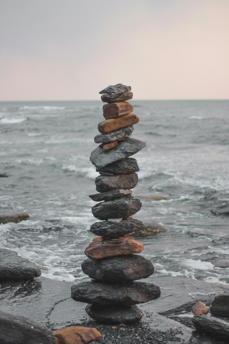 A tall cairn on a rock by the sea